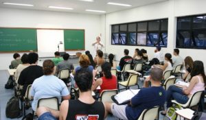 retorno ao presencial_alunos de faculdade brasileira sentados em cadeira