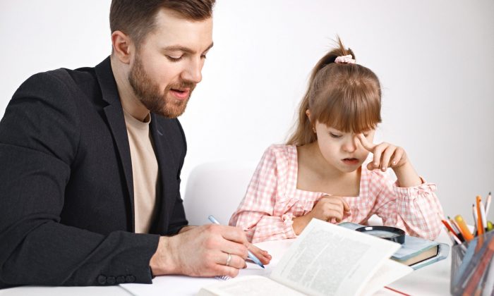 Girl with Down syndrome studying with her teacher at home